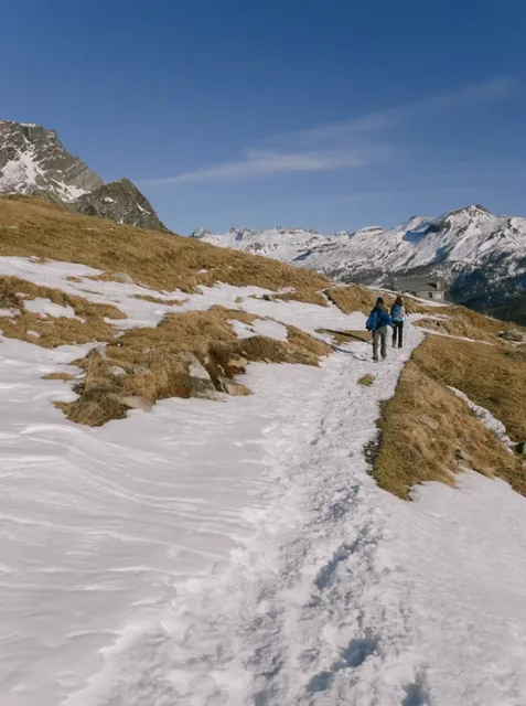 Trekkers walking through a snowy Himalayan landscape