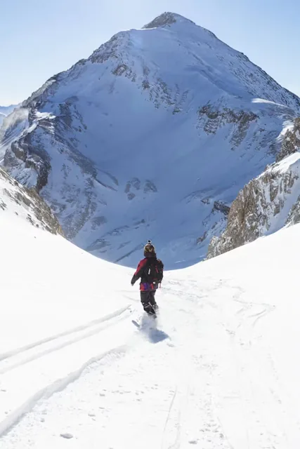 Trekkers walking through a snowy Himalayan landscape