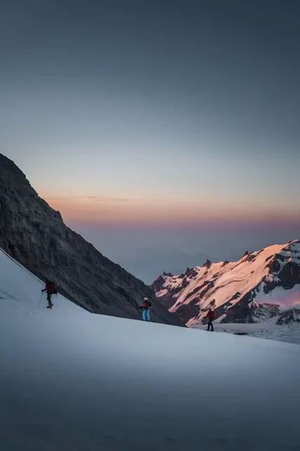 Trekkers walking through a snowy Himalayan landscape