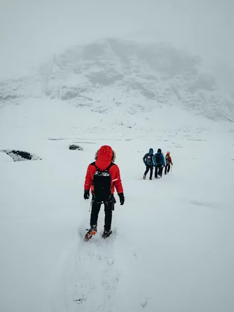 Trekkers walking through a snowy Himalayan landscape