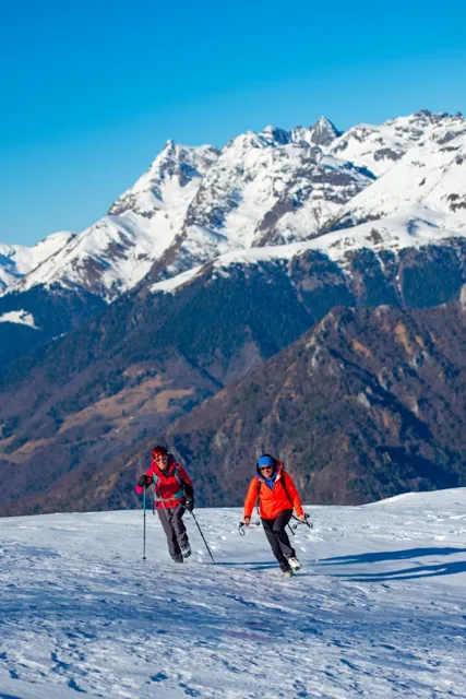 Trekkers walking through a snowy Himalayan landscape