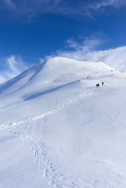 Trekkers walking through a snowy Himalayan landscape