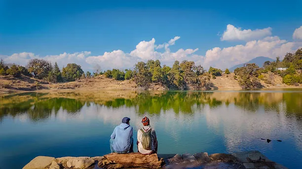 Travellers sitting beside a mountain lake