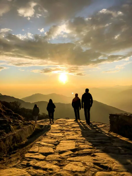 Travellers watching the sunrise from a summit